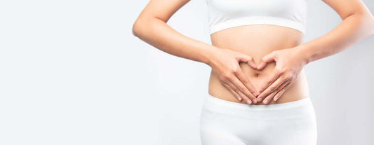 a woman holding her stomach and showing the heart symbol as she has a healthy gut from digestive enzyme pro blend